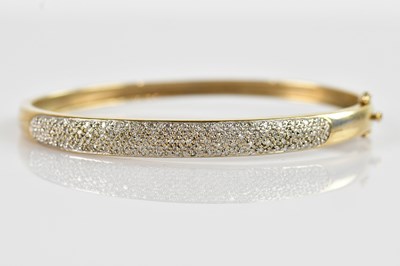 Lot 1200 - A yellow metal diamond set hinged snap bangle,...