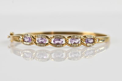 Lot 1180 - A yellow metal diamond and amethyst set hinged...