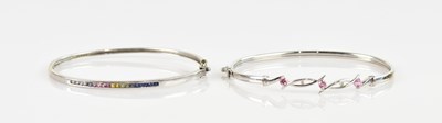 Lot 1214 - A white metal multigem set hinged snap bangle...