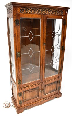 Lot 27 - An Old Charm carved oak glazed bookcase or...
