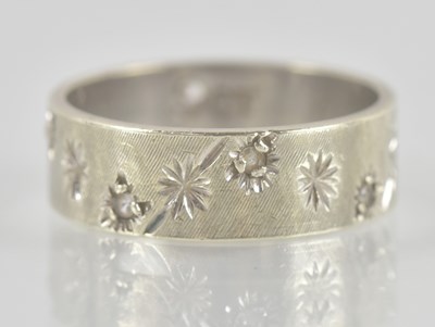 Lot 1346 - A 9ct white gold band ring, with oscillating...