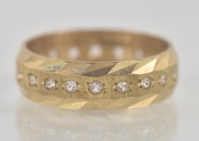 Lot 1354 - A 9ct yellow gold band of small white stones...