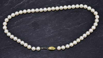 Lot 1393 - A string of cultured pearls with yellow metal...