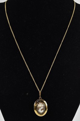 Lot 1403 - A 9ct gold pendant with an oval bezel set...