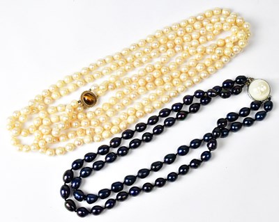 Lot 725 - A long double-strand faux pearl necklace with...