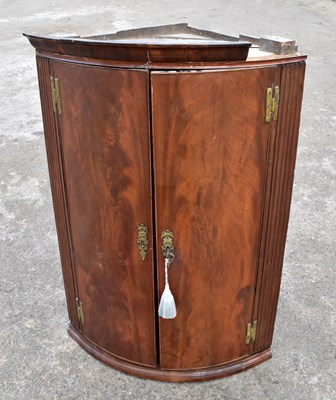 Lot 1703 - An early 19th century mahogany two door wall hanging bow fronted corner cupboard