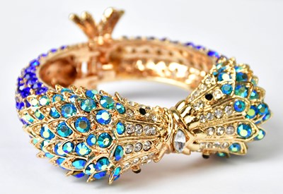 Lot 750 - A hinged bangle in the form of two mythical...