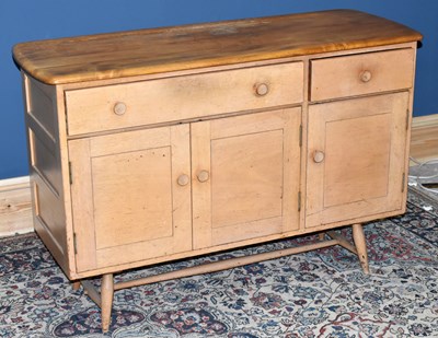 Lot 1406 - ERCOL; a mid century light elm sideboard with...