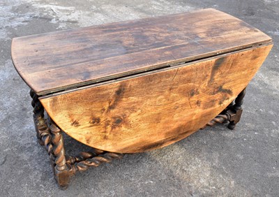 Lot 1686 - A substantial antique oak oval drop-leaf dining table