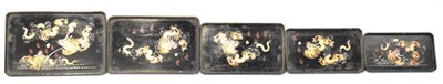 Lot 210 - A graduated set of five black lacquered trays...