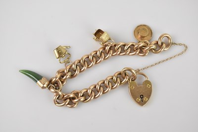 Lot 1153 - A yellow metal curb link charm bracelet,...