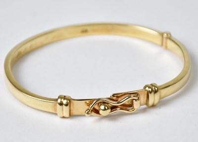 Lot 863 - A 9ct gold bangle with clip clasp, marked 9ct,...