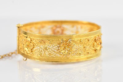 Lot 1091 - A Russian yellow metal hinged snap bangle,...