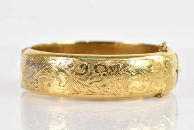 Lot 2228 - A yellow metal hinged snap bangle, with chased...