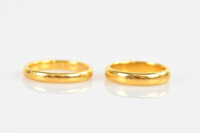 Lot 2299 - Two 22ct gold wedding bands, size K and O,...