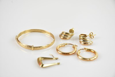 Lot 1211 - A yellow metal Christening bangle, stamped...