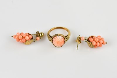 Lot 2446 - A 9ct yellow gold and carved coral dress ring,...