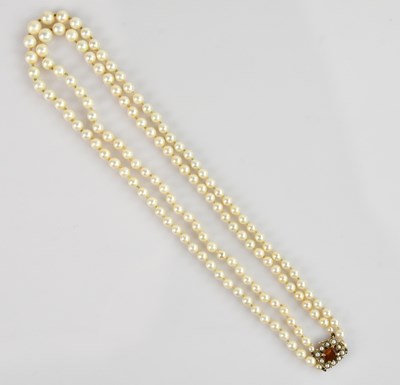 Lot 2155 - A two strand pearl necklace, set with a 9ct...