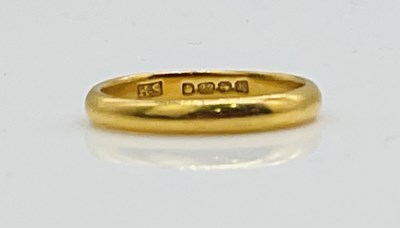 Lot 670 - A 22ct yellow gold wedding band, size K,...