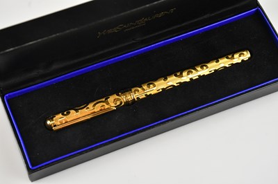 Lot 1186 - YVES SAINT LAURENT; a gold tone ballpoint pen,...