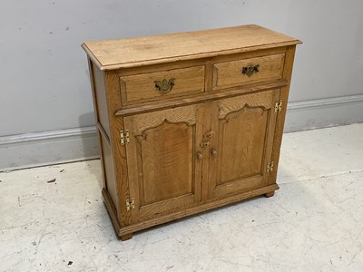 Lot 2064 - A modern light oak cupboard, with two drawers...