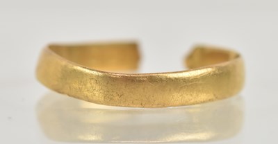 Lot 1290 - A 22ct gold band ring with cut shank, approx 1....