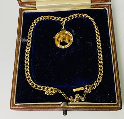 Lot 203 - An Edwardian boxed yellow metal pig pendant,...