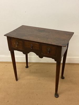 Lot 304 - A George III oak lowboy, raised on tapering...
