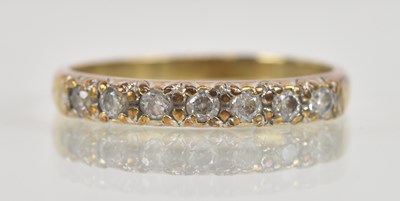 Lot 1300 - A 9ct yellow gold half hoop white stone set...