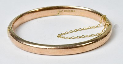 Lot 865 - A 9ct gold bangle with engraved foliate...