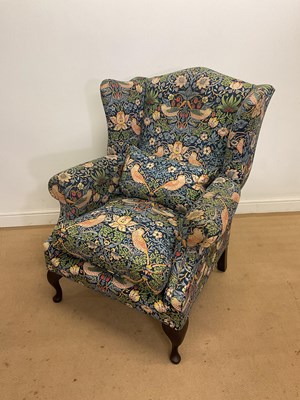 Lot 265 - A large wingback armchair, raised on cabriole...