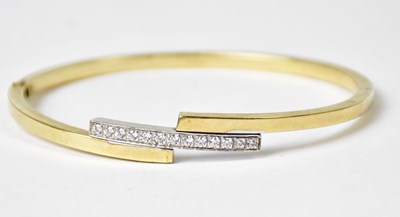 Lot 871 - A yellow metal bangle with central white metal...