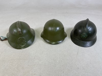 Lot 45 - Three military helmets, to include a French...