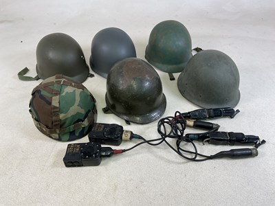 Lot 38 - American GI helmets, including a camouflaged...
