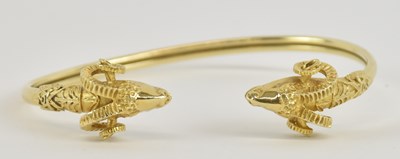 Lot 1411 - A yellow metal 'ram' torque bangle, with...