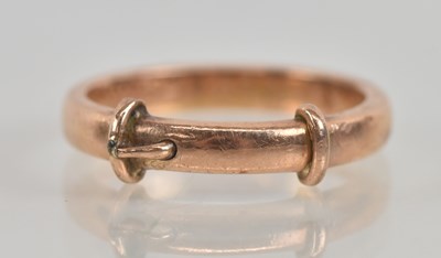 Lot 1226 - A yellow metal ‘buckle’ band ring, inscribed...
