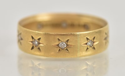 Lot 1245 - An 18ct yellow gold diamond set band ring, set...