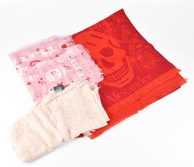 Lot 1213 - ALEXANDER MCQUEEN; a red 100% wool skull scarf,...