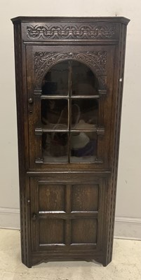 Lot 81 - A reproduction carved oak corner cupboard,...