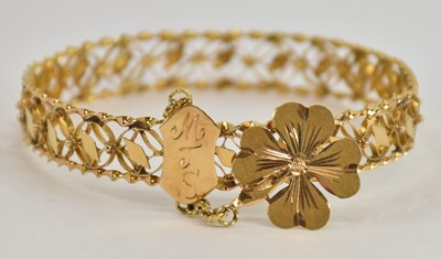 Lot 1401 - An 18ct yellow gold hinged bangle, inscribed...