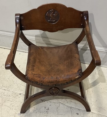 Lot 174 - A Continental carved oak X framed elbow chair.