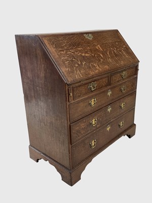 Lot 1052 - A George III oak bureau, with fall enclosing a...