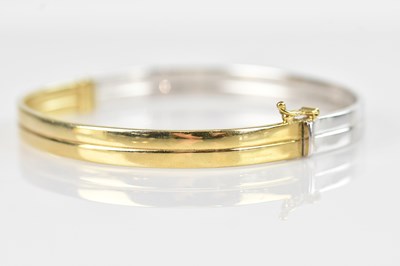 Lot 104 - A yellow and white metal hinged snap bangle,...