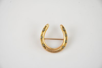 Lot 189 - A yellow metal novelty horseshoe brooch, tests...