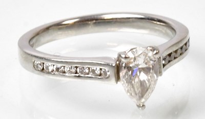 Lot 704 - A platinum ring set with a central pear-shaped...