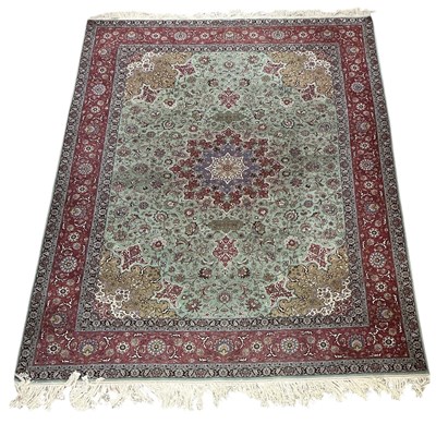 Lot 77 - A large Persian red ground wool pile florally...