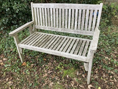 Lot 1155 - A folding teak garden bench, length 112cm.
