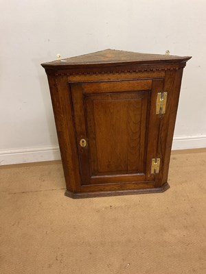 Lot 579 - A 18th century oak corner cabinet, with brass...