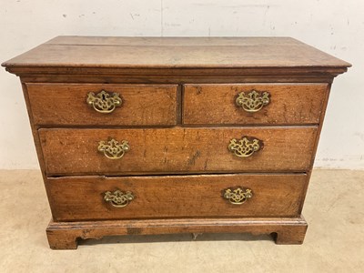 Lot 679 - A small Georgian oak chest of drawers with two...