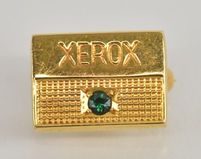 Lot 1397 - A 9ct yellow gold ‘Xerox’ emerald set brooch,...